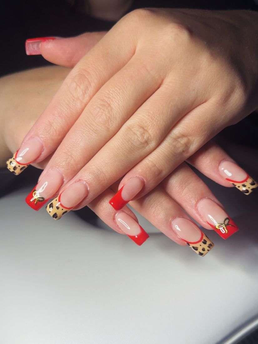 Nude nails with red French tips and leopard print accents